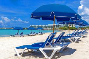 a row of chairs and umbrellas on a beach at The Atrium Beach Resort and Spa Sint Maarten, Ascend Hotel Collection in Simpson Bay