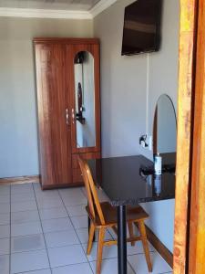 a room with a table with a chair and a mirror at Phiris B&B in Esperanza