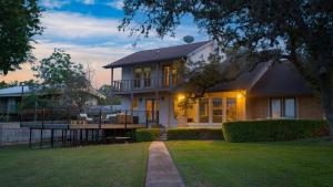 a large house with a porch and a yard at Travis by AvantStay Waterfront Lake Retreat in Lakeway