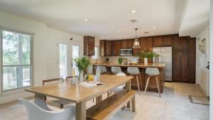 a kitchen with a wooden table and chairs at Travis by AvantStay Waterfront Lake Retreat in Lakeway