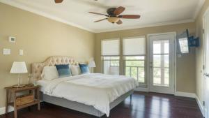a bedroom with a bed with a ceiling fan at Travis by AvantStay Waterfront Lake Retreat in Lakeway