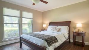 レイクウェイにあるTravis by AvantStay Waterfront Lake Retreatの2つの窓と天井扇風機のあるベッドのある寝室
