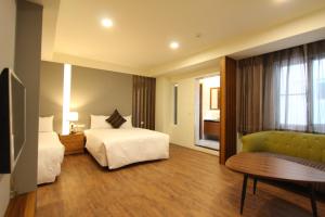 una camera d'albergo con due letti e un divano di Hido Hostel III a Kenting