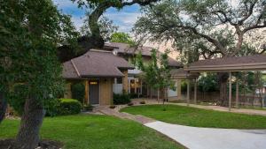 レイクウェイにあるTravis by AvantStay Waterfront Lake Retreatの前庭に木のある家