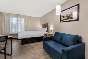 a hotel room with a couch and a bed at MainStay Suites Sterling near Dulles Town Center in Sterling