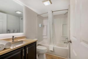 a bathroom with a sink and a toilet and a shower at MainStay Suites Sterling near Dulles Town Center in Sterling +32 photos