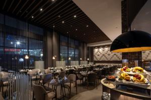 a dining room with tables and chairs and a buffet at Wyndham Grand Costa Del Sol Lima Airport in Lima