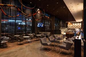 a restaurant with chairs and tables and a bar at Wyndham Grand Costa Del Sol Lima Airport in Lima