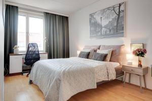 a bedroom with a bed and a desk and a chair at Central Luxury Stay w Vintage Charm & Sauna in Helsinki