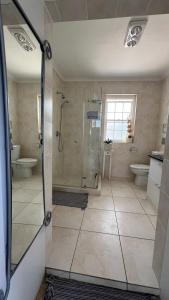 a bathroom with a shower and two toilets at Villa Barry in Hout Bay