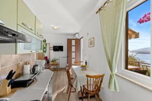 a kitchen with a table and a large window at Apartment Neda in Rabac - Bay View in Rabac