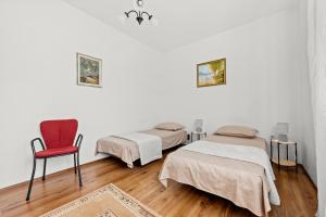 a room with two beds and a red chair at Apartment Neda in Rabac - Bay View in Rabac