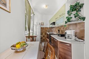 a kitchen with a table with a bowl of fruit on it at Apartment Neda in Rabac - Bay View in Rabac +16 photos