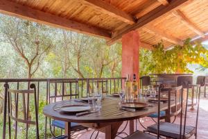 a wooden table with wine glasses on a deck at Gite Baba in Puget-Ville