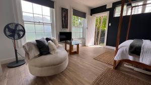 a living room with a white chair and a fan at Villa Barry in Hout Bay