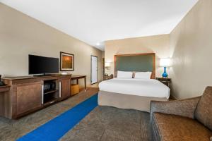 a hotel room with a bed and a flat screen tv at Quality Inn - Pratt in Pratt
