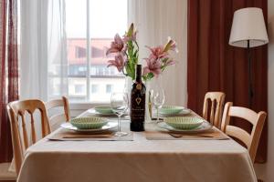 a table with a bottle of wine and a vase of flowers at Central Luxury Stay w Vintage Charm & Sauna in Helsinki
