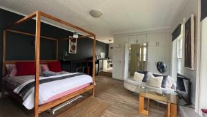 a bedroom with a canopy bed and a couch at Villa Barry in Hout Bay