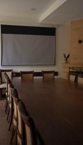 a conference room with a large projection screen and chairs at Faria Boutique Hotel in Tsaghkadzor