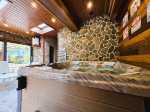 a large tub in a room with a stone wall at Villa Simona in Rajecké Teplice +30 photos