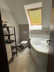 a bathroom with a tub and a toilet and a sink at Saint Michael - Garni Hotel in Trnava +37 photos