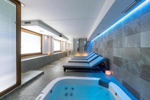 a bathroom with a tub and a row of seats at Wine Hotel Retici Balzi in Poggiridenti