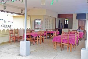 a restaurant with pink tables and wooden chairs at Funguni Palace Hotel in Zanzibar City