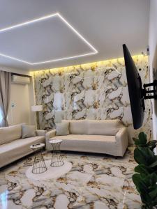 塞雷Modern central apartment的客厅设有两张沙发和一堵石墙