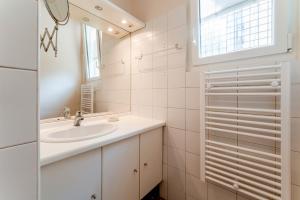 a white bathroom with a sink and a mirror at La Ruche des Abeilles in Avignon +18 photos
