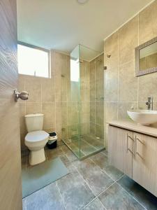 a bathroom with a toilet and a sink and a shower at Lindo apartamento en excelente zona Central Urban Mzles in Manizales