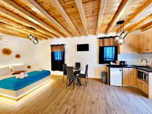 a bedroom with a bed and a table and a kitchen at Mykonian Breeze in Ano Mera