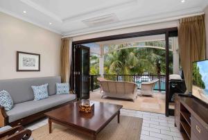 a living room with a couch and a tv at Eden Island Luxury Accommodation in Eden Island