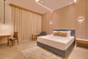 Un dormitorio con una cama, una mesa y un escritorio. en Lemon Tree Hotel Morbi,  32 fotos más