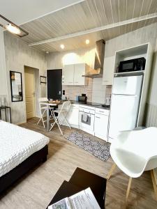 Habitación con cocina con cama y mesa. en Résidence Victoria, en Vichy
