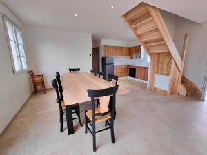 een keuken en eetkamer met een houten tafel en stoelen bij Gite des Polders in Saint-Quentin-en-Tourmont