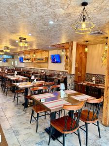 een eetkamer met houten tafels en stoelen bij Residencial DB in Luanda