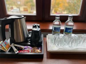 two bottles of water and glasses on a table at Saint Michael - Garni Hotel in Trnava