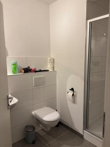 a white bathroom with a toilet and a shower at Aquamarine - Central and cozy in Kassel