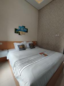 a bedroom with a large white bed with two pillows at Mutu Edutel in Panggungrejo
