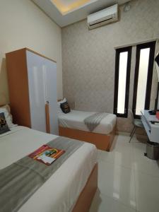 a hotel room with two beds and a sink at Mutu Edutel in Panggungrejo
