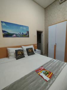 a bedroom with a white bed with two pillows at Mutu Edutel in Panggungrejo