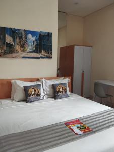a bedroom with a white bed with pillows at Mutu Edutel in Panggungrejo