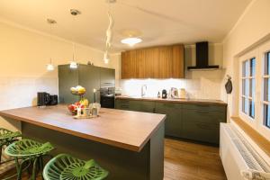 una cucina con armadi verdi e piano di lavoro in legno di Haus Fasanenwiese 