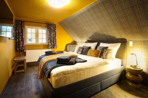 a bedroom with a large bed with yellow walls at Haus Fasanenwiese 