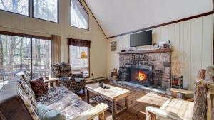 a living room with a couch and a fireplace at Grateful Escape AvantStay Hot Tub Sauna Deck Firepit Beach Access in Lake Harmony