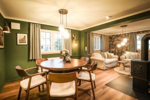 a dining room with green walls and a table and chairs at Haus Fasanenwiese 