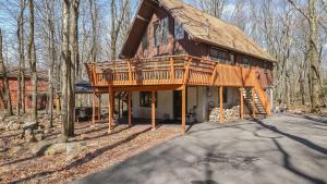 Una casa con una gran terraza a un lado. en Grateful Escape AvantStay Hot Tub Sauna Deck Firepit Beach Access, en Lake Harmony