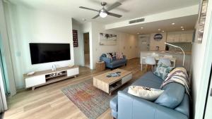 un soggiorno con un divano blu e una TV a schermo piatto di On The Doorstep Of Woorim Surf Beach a Woorim