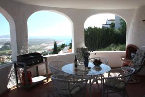 - Balcón con ventanas, mesa y sillas en Villa Celeste, en Velilla