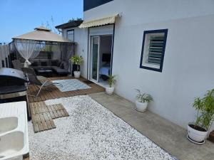 a patio with a couch and a table at Danigora Family, Détente et randonnées in Saint-Paul